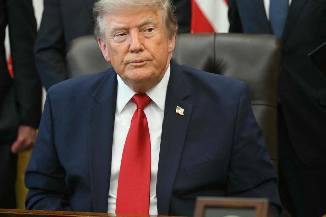US President Donald Trump looks on after signing an executive order to drastically shrink two national monuments in Utah, paving the way for fossil fuel extraction and mining. (Photo by SAUL LOEB / AFP)