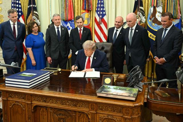 US President Donald Trump signs an executive order to drastically shrink two national monuments in Utah, paving the way for fossil fuel extraction and mining. (Photo by SAUL LOEB / AFP)