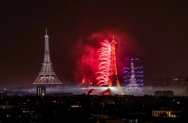 Fireworks and drones light up the sky around the Eiffel Tower during a choreographed show marking Bastille Day in Paris on July 13, 2026, on the eve of the annual Bastille Day parade in the French capital. (Photo by Martin BUREAU / AFP)