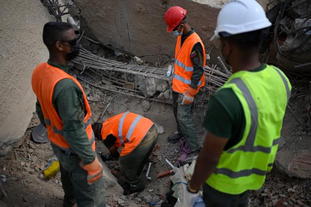 Venezuelan military personnel search for bodies amid the rubble of a collapsed building in Los Corales, La Guaira state, Venezuela on July 13, 2026, following twin earthquakes that struck the region. The death toll from the twin earthquakes that struck Venezuela nearly three weeks ago has surpassed 4,500, while the number of injured remains at about 17,000, according to the latest government report released on July 13. (Photo by Federico PARRA / AFP)
