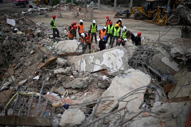 Venezuelan military personnel and rescue workers search for bodies amid the rubble of a collapsed building in Los Corales, La Guaira state, Venezuela on July 13, 2026, following twin earthquakes that struck the region. The death toll from the twin earthquakes that struck Venezuela nearly three weeks ago has surpassed 4,500, while the number of injured remains at about 17,000, according to the latest government report released on July 13. (Photo by Federico PARRA / AFP)