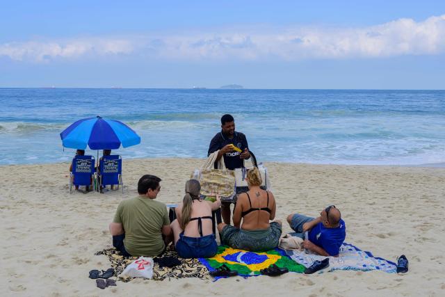 A beach vendor receives payment through Brazil's Pix instant payment system at Copacabana Beach in Rio de Janeiro, Brazil, on July 9, 2026. It started as a payment tool and became a source of national pride. In just a few years, Brazil's PIX established itself as the dominant payment method in Latin America's largest economy. But in the process, it stepped on the toes of powerful interests in the United States. (Photo by Pablo PORCIUNCULA / AFP)