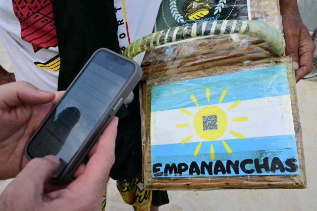 A man pays for a purchase at Copacabana Beach using Brazil's Pix instant payment system in Rio de Janeiro, Brazil, on July 9, 2026. It started as a payment tool and became a source of national pride. In just a few years, Brazil's PIX established itself as the dominant payment method in Latin America's largest economy. But in the process, it stepped on the toes of powerful interests in the United States. (Photo by Pablo PORCIUNCULA / AFP)