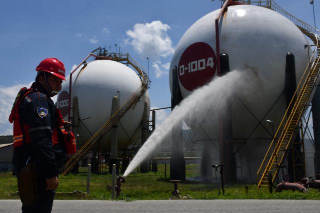 (FILES) A worker of the Venezuelan state oil company PDVSA participates in a drill to reduce risks from natural disasters or armed conflicts at the El Palito refinery in Puerto Cabello, Carabobo State, Venezuela, on September 27, 2025. Venezuela's leader Delcy Rodriguez assured on July 13, 2026, that oil production in the country was "not affected" by the double earthquakes that killed more than 4,500 people last month. (Photo by AFP)