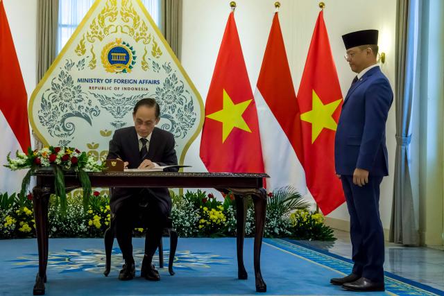 Vietnamese Foreign Minister Bui Thanh Son (L) signs the guestbook as Indonesian Foreign Minister Sugiono (R) looks on during the Joint Commission for Bilateral Cooperation (JCBC) meeting at the Ministry of Foreign Affairs office in Jakarta on July 14, 2026. (Photo by ADITYA IRAWAN / AFP)
