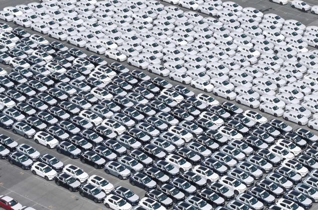 Chinese-made cars are seen before being loading for export at the vehicle export terminal in the port of Shanghai on July 14, 2026. Chinese exports jumped more than a quarter last month, official data showed on July 14, providing a fresh boost to leaders as they look to kickstart growth in the world's second-largest economy. (Photo by CN-STR / AFP) / China OUT