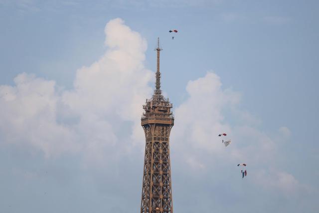 French Air and Space army parachutists display a French national flag in the air next to the Eiffel Tower ahead of the annual Bastille Day military parade in Paris on July 14, 2026. (Photo by Ludovic MARIN / AFP)