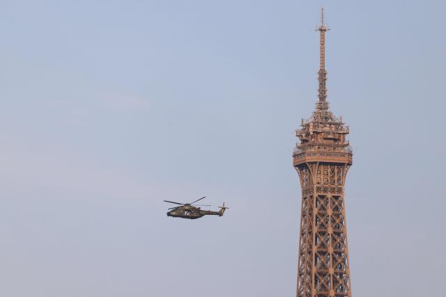 An NHIndustries NH90 helicopter flies next to the Eiffel Tower ahead of the annual Bastille Day military parade in Paris on July 14, 2026. (Photo by Ludovic MARIN / AFP)