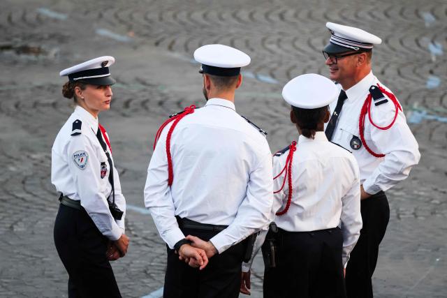Members of the French national police (Police Nationale) discuss before the annual Bastille Day military parade in Paris on July 14, 2026. (Photo by Ludovic MARIN / AFP)