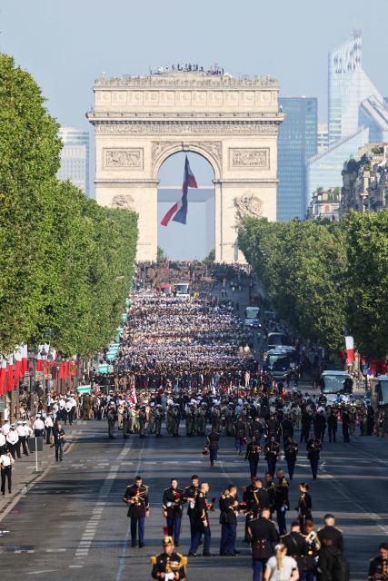 Troops get ready for the annual Bastille Day military parade on the Champs-Elysees Avenue with the Arc de Triomphe in the background in Paris on July 14, 2026. (Photo by Ludovic MARIN / AFP)