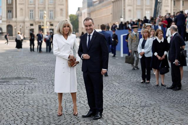 France's Prime Minister Sebastien Lecornu (R) speaks with French President's wife Brigitte Macron upon arrival for the annual Bastille Day military parade on the Place de la Concorde in Paris on July 14, 2026. (Photo by Benoit Tessier / POOL / AFP)
