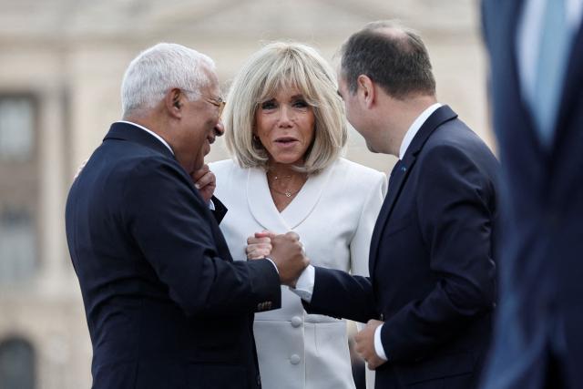 France's Prime Minister Sebastien Lecornu (R) and French President's wife Brigitte Macron (C) welcome European Council President Antonio Costa for the annual Bastille Day military parade on the Place de la Concorde in Paris on July 14, 2026. (Photo by Benoit Tessier / POOL / AFP)