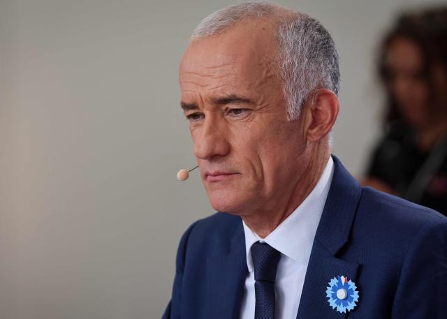 French journalist Gilles Bouleau waits for the start of the annual Bastille Day military parade on the Champs-Elysees Avenue in Paris on July 14, 2026. (Photo by Ludovic MARIN / AFP)