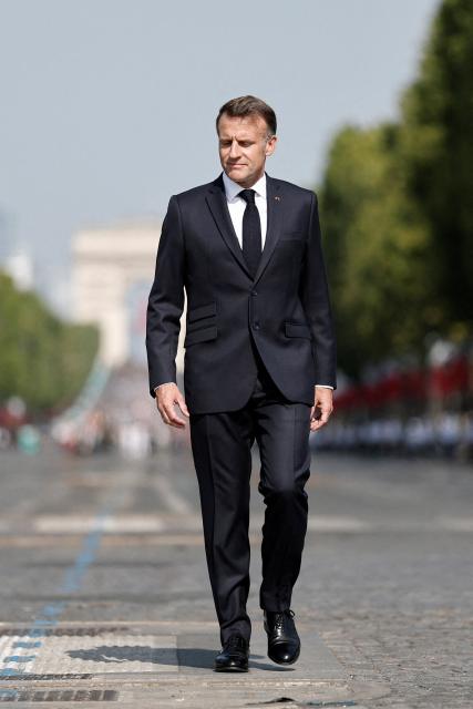 France's President Emmanuel Macron reviews troops on the Place de la Concorde with the Arc de Triomphe in the background during the annual Bastille Day military parade in Paris on July 14, 2026. (Photo by Benoit Tessier / POOL / AFP)