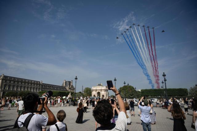 France's Air Force Elite aerobatic flying team "Patrouille de France" (PAF) releases trails of France's national colours as they perform a flyover during the annual Bastille Day military parade on the Place du Carroussel with the Arc de Triomphe du Carroussel in the background in Paris on July 14, 2026. (Photo by Martin BUREAU / AFP)