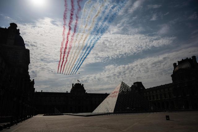 France's Air Force Elite aerobatic flying team "Patrouille de France" (PAF) releases trails of France's national colours as they perform a flyover during the annual Bastille Day military parade on the Court Carre with the Louvre Pyramid, designed by Chinese-US architect Ieoh Ming Pei and the Louvre Museum in Paris on July 14, 2026. (Photo by Martin BUREAU / AFP)