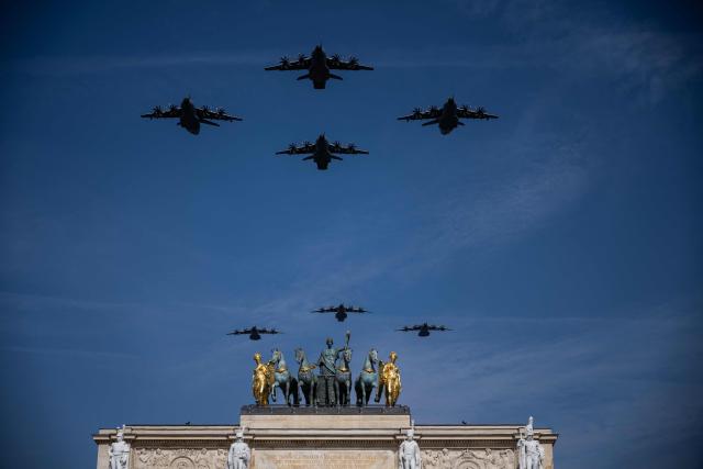 Military aircrafts perform a flyover during the annual Bastille Day military parade over the Arc de Triomphe du Carroussel and its copy of the quadriga of the horses of Saint Mark in Paris on July 14, 2026. (Photo by Martin BUREAU / AFP)