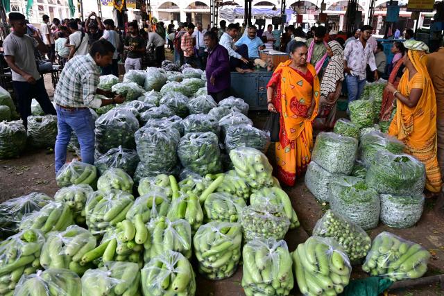 Customers buy vegetables at a wholesale market in Ahmedabad on July 14, 2026. (Photo by Shammi MEHRA / AFP)