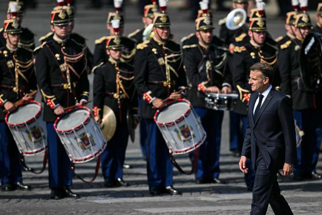 France's President Emmanuel Macron reviews troops during the annual Bastille Day military parade on the Champs-Elysees Avenue in Paris on July 14, 2026. (Photo by LOU BENOIST / AFP)