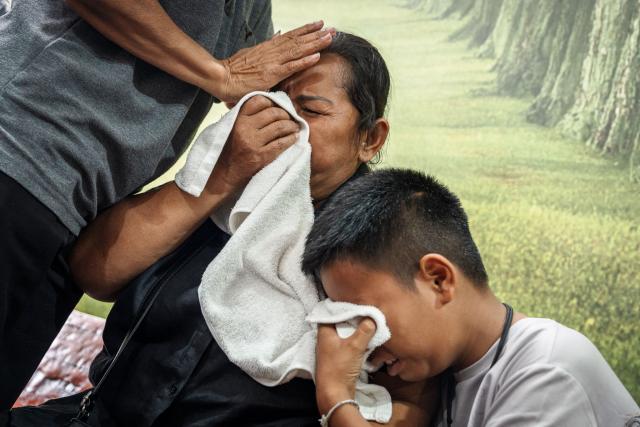 Relatives mourn victims killed in a bar fire at the Police General Hospital in Bangkok on July 14, 2026. Grieving relatives of the victims of a huge Bangkok bar fire claimed their bodies on July 14 as the death toll rose to 30, even as others held out hope that missing loved ones were alive. (Photo by chanakarn LAOSARAKHAM / AFP)