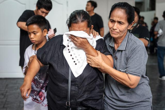 Relatives mourn victims killed in a bar fire at the Police General Hospital in Bangkok on July 14, 2026. Grieving relatives of the victims of a huge Bangkok bar fire claimed their bodies on July 14 as the death toll rose to 30, even as others held out hope that missing loved ones were alive. (Photo by chanakarn LAOSARAKHAM / AFP)