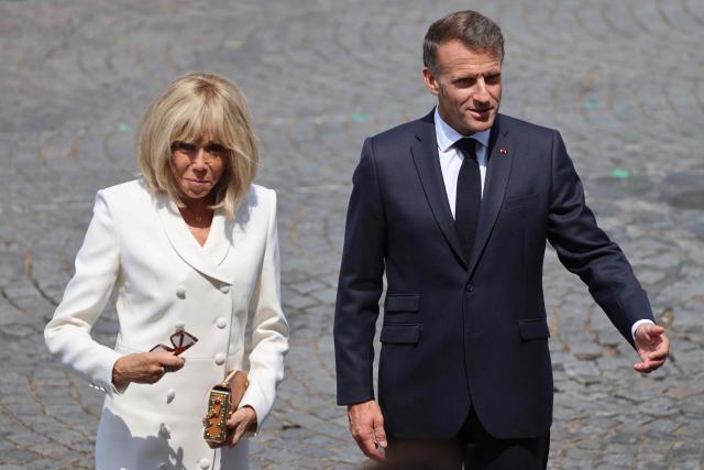 France's President Emmanuel Macron (R) and his wife Brigitte Macron attend the annual Bastille Day military parade on the Champs-Elysees Avenue in Paris on July 14, 2026. (Photo by Ludovic MARIN / AFP)
