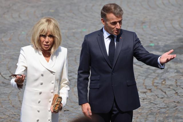 France's President Emmanuel Macron (R) and his wife Brigitte Macron attend the annual Bastille Day military parade on the Champs-Elysees Avenue in Paris on July 14, 2026. (Photo by Ludovic MARIN / AFP)