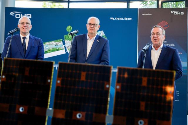 (L-R) Marco Fuchs, CEO of the OHB group, Andreas Bovenschulte, President of the Senate and Mayor of Bremen, and German Defence Minister Boris Pistorius speaks give a press briefing at the headquarters of German aerospace and technology company OHB in Bremen, northwestern Germany, on July 14, 2026. Pistorius visited OHB during his summer tour throughout Germany. According to the group, it covers "the entire spectrum of modern space technologies", with activities ranging "from the development of complete satellite systems and space missions to infrastructure for access to space, as well as data-driven applications and digital services". (Photo by FOCKE STRANGMANN / AFP)