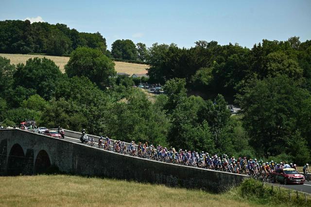 Tour de France director Christian Prudhomme gestures from atop his race direction vehicle to give the start to the pack of riders (peloton) at the start of the 10th stage of the 113th edition of the Tour de France cycling race, 166,6 km between Aurillac and Le Lioran in the Massif Central, on July 14, 2026. (Photo by Loic VENANCE / AFP)
