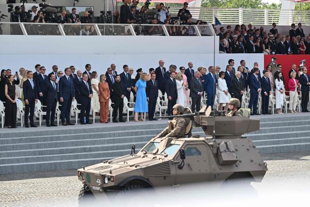 France's President Emmanuel Macron (C) attends alongside his wife Brigitte Macron (C-R), France's Prime Minister Sebastien Lecornu (C-L), French government officials and international leaders the annual Bastille Day military parade at the Place de la Concorde in Paris on July 14, 2026. (Photo by LOU BENOIST / AFP)
