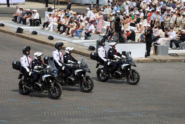 French police officers of the Repression of Violent Action Motorised Brigade (Brav-M or Brigade de repression de l'action violente motorisee) drive during the annual Bastille Day military parade on the Champs-Elysees Avenue in Paris on July 14, 2026. (Photo by Ludovic MARIN / AFP)