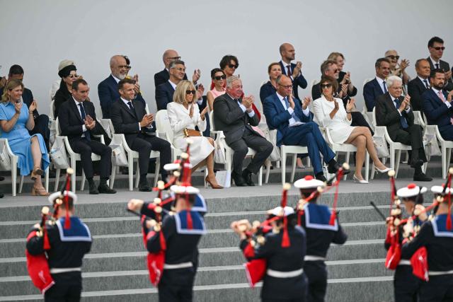 (From L - first row) President of the French National Assembly Yael Braun-Pivet, France's Prime Minister Sebastien Lecornu, France's President Emmanuel Macron and his wife Brigitte Macron, President of the French Senate Gerard Larcher and German Chancellor Friedrich Merz react during the annual Bastille Day military parade at the Place de la Concorde in Paris on July 14, 2026. (Photo by LOU BENOIST / AFP)