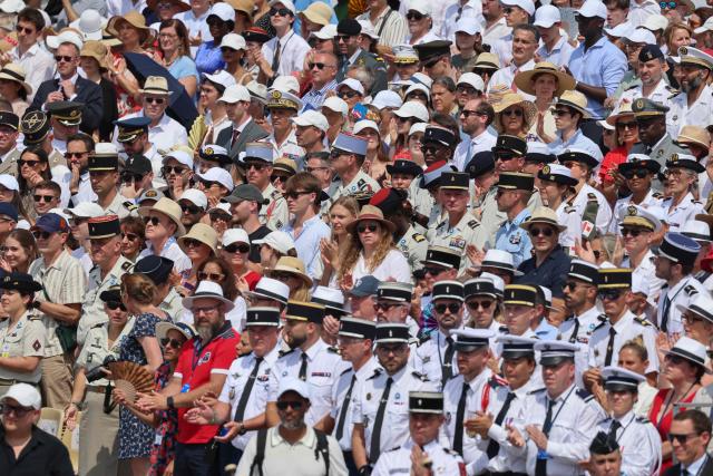 Guests and troops applaud during the annual Bastille Day military parade on the Champs-Elysees Avenue in Paris on July 14, 2026. (Photo by Ludovic MARIN / AFP)