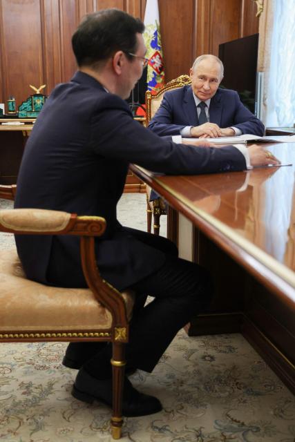 In this pool photograph distributed by the Russian state agency Sputnik, Russia's President Vladimir Putin meets with the head of the Republic of Sakha (Yakutia) Aisen Nikolaev in Moscow on July 14, 2026. (Photo by Gavriil Grigorov / POOL / AFP)