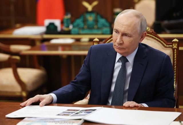 In this pool photograph distributed by the Russian state agency Sputnik, Russia's President Vladimir Putin attends a meeting with the head of the Republic of Sakha (Yakutia) in Moscow on July 14, 2026. (Photo by Gavriil Grigorov / POOL / AFP)