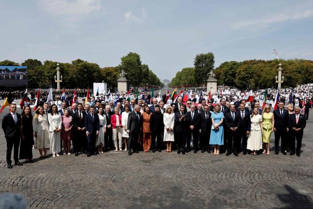 France's President Emmanuel Macron (C) poses for a family photo at the end of the annual Bastille Day military parade on the Champs-Elysees Avenue in Paris on July 14, 2026. (Photo by Benoit Tessier / POOL / AFP)