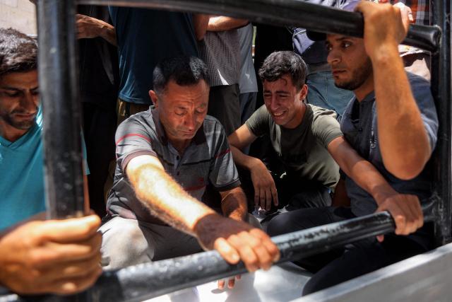EDITORS NOTE: Graphic content / Men react during the funeral for several victims killed after a police station was was hit by Israeli bombardment in the Jabalia camp for Palestinian refugees in the northern Gaza Strip, in Gaza City on July 14, 2026. Gaza's civil defence agency and the hospital said that the Israeli airstrike on the police station in northern Gaza killed eight people on July 14, including a woman officer. In a statement condemning the strike, Palestinian Islamist movement Hamas, which controls Gaza's police force, said that the police station chief was among those killed. (Photo by Omar AL-QATTAA / AFP)
