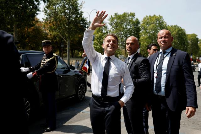France's President Emmanuel Macron waves as he leaves after the annual Bastille Day military parade on the Place de la Concorde in Paris on July 14, 2026. (Photo by Benoit Tessier / POOL / AFP)