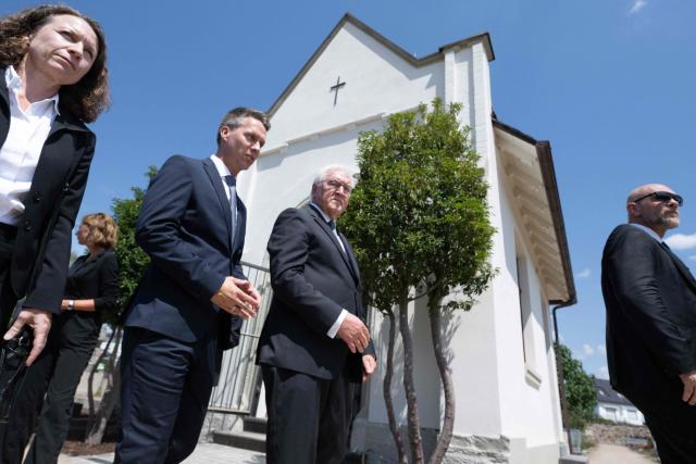 German President Frank-Walter Steinmeier (C-R) and Pascal Rowald (C-L), mayor of Bad Neuenahr, leave after laying a wreath on July 14, 2026 at the cemetery chapel in Ahrweiler, western Germany, to commemorate the victims of the dramatic floods from July 2021. More than 180 people lost their lives five years ago in severe floods that pummelled western Germany in mid-July 2021, raising questions about whether enough was done to forewarn residents. (Photo by Boris Roessler / POOL / AFP)