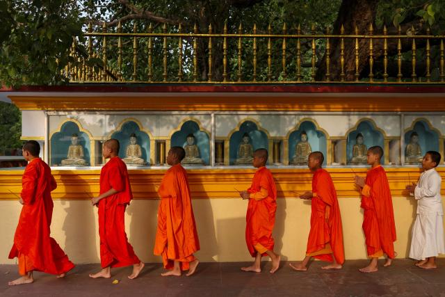 Young Buddhist monks pray around statues of Buddha at the Bodhi Mandap inside the Mulagandha Kuti Vihar complex, a Buddhist monastery and temple, at Sarnath on the outskirts of Varanasi on July 14, 2026. (Photo by Niharika KULKARNI / AFP)