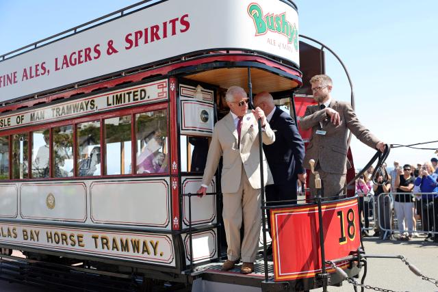Britain's King Charles III (C) rides on one of the horse trams along the promenade in Douglas on the Isle of Man, an island in the Irish Sea off of the west coast England, on July 14, 2026, to celebrate 150 years of the Douglas Horse Tramway. (Photo by Chris Jackson / POOL / AFP)