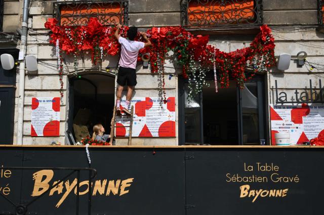 A man decorates his bar ahead of the opening of the Bayonne Festival, in Bayonne, south-western France, on July 14, 2026. The Bayonne Festival runs from July 15 to July 19, 2026. (Photo by Gaizka IROZ / AFP)