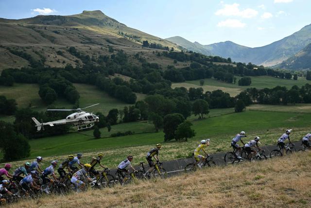 The pack of riders (peloton) cycles during the 10th stage of the 113th edition of the Tour de France cycling race, 166,6 km between Aurillac and Le Lioran in the Massif Central, on July 14, 2026. (Photo by Loic VENANCE / AFP)