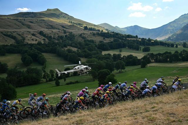The pack of riders (peloton) cycles during the 10th stage of the 113th edition of the Tour de France cycling race, 166,6 km between Aurillac and Le Lioran in the Massif Central, on July 14, 2026. (Photo by Loic VENANCE / AFP)