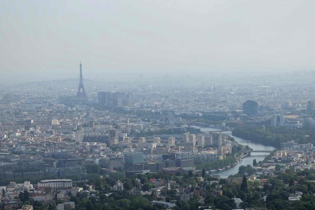 This aerial photograph taken on July 14, 2026, shows the Eiffel Tower and the river Seine seen from the western surburb of Paris. (Photo by Thomas SAMSON / AFP)