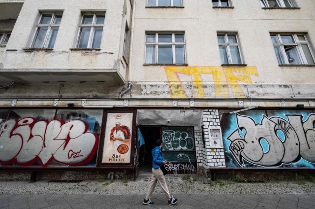 A recently-closed restaurant's windows are covered in graffiti in Berlin's Prenzlauer Berg district on July 14, 2026. High inflation rates and lingering geopolitical uncertainties in Germany have resulted in flatlining private consumption and sluggish residential construction. (Photo by John MACDOUGALL / AFP)