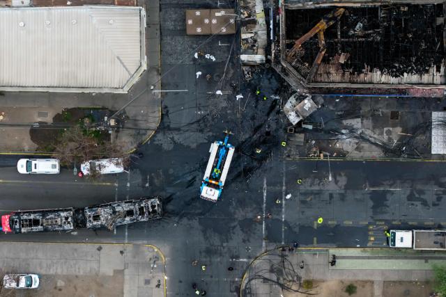 Aerial view after a van collided with a Metropolitan Transport Network (RED) bus in the Franklin neighborhood, Santiago, Chile, on July 14, 2026. Five people died in an accident between a van and a bus which caused a fire that engulfed the public transport vehicle and commercial premises. (Photo by Javier TORRES / AFP)