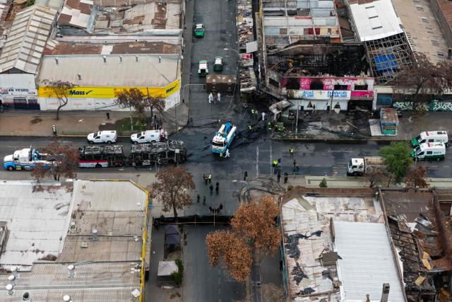 Aerial view after a van collided with a Metropolitan Transport Network (RED) bus in the Franklin neighborhood, Santiago, Chile, on July 14, 2026. Five people died in an accident between a van and a bus which caused a fire that engulfed the public transport vehicle and commercial premises. (Photo by Javier TORRES / AFP)