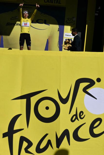 UAE Team Emirates - XRG's Slovenian rider Tadej Pogacar celebrates on the podium with the overall leader's yellow jersey after the 10th stage of the 113th edition of the Tour de France cycling race, 166,6 km between Aurillac and Le Lioran in the Massif Central, on July 14, 2026. (Photo by Jeff PACHOUD / AFP)