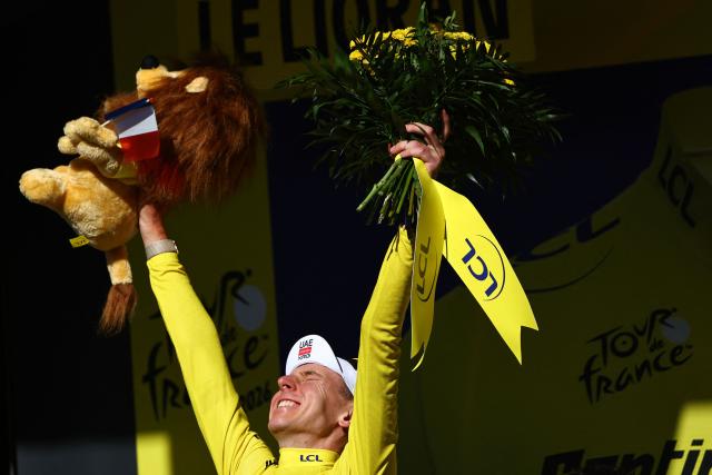 UAE Team Emirates - XRG's Slovenian rider Tadej Pogacar celebrates on the podium with the overall leader's yellow jersey after the 10th stage of the 113th edition of the Tour de France cycling race, 166,6 km between Aurillac and Le Lioran in the Massif Central, on July 14, 2026. (Photo by Anne-Christine POUJOULAT / AFP)